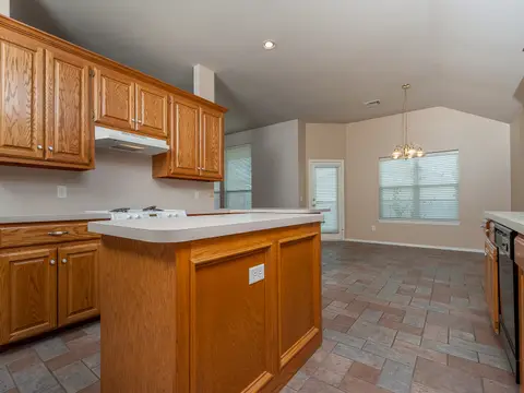 An oak kitchen with an island, tile floor, and a breakfast nook